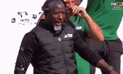 Man In Jets Jacket Talking On Phone GIF