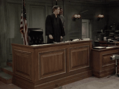 Man In Judge Robe Holding Gavel In Courtroom GIF