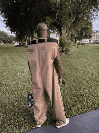 Man In Jumpsuit With Belt Standing In Park GIF