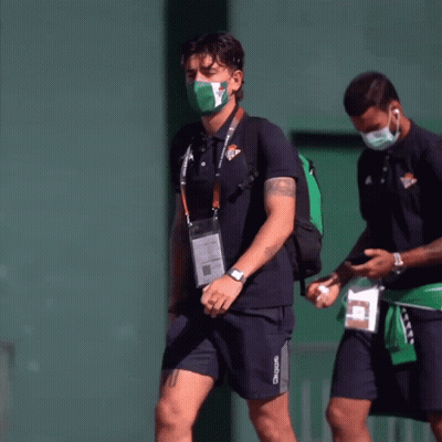 Man In Kappa Shirt Walking With Masked Man GIF