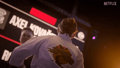 Man In Karate Uniform In Front Of Netflix Sign GIF