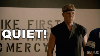 Man In Karate Uniform In Front Of Quiet Sign GIF