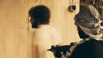 Man In Keffiyeh Holding Gun, Another Man Behind GIF