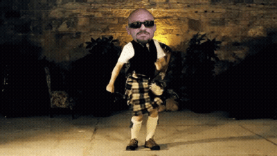 Man In Kilt Dancing In Front Of Brick Wall GIF