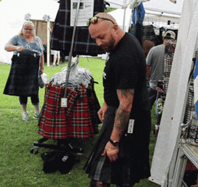 Man In Kilt In Front Of Kilt Display GIF