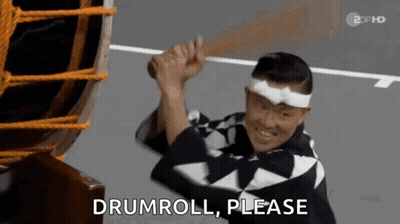 Man In Kimono Holding Drum Saying Drumroll Please GIF