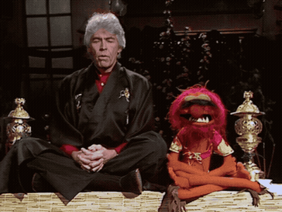 Man In Kimono In Lotus Position With Stuffed Animal GIF