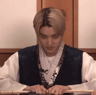 Man In Kimono Sitting At Table With Stick GIF