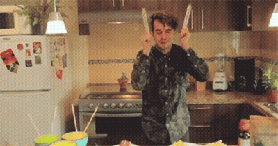 Man In Kitchen Holding Chopsticks To Ears GIF