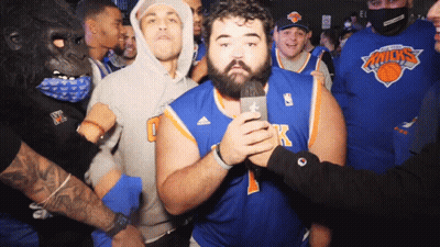 Man In Knicks Jersey Holding Microphone In Front Of Crowd GIF