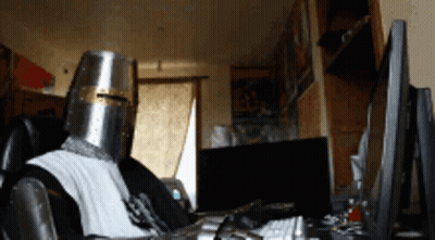 Man In Knight Helmet At Computer GIF