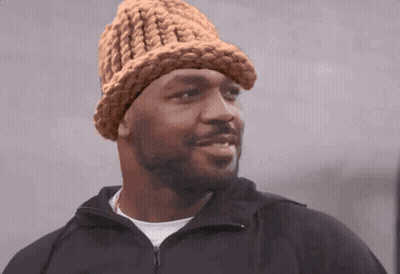 Man In Knitted Hat And Black Jacket Looking At Camera GIF