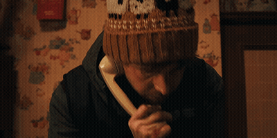 Man In Knitted Hat With North Talking On Phone GIF