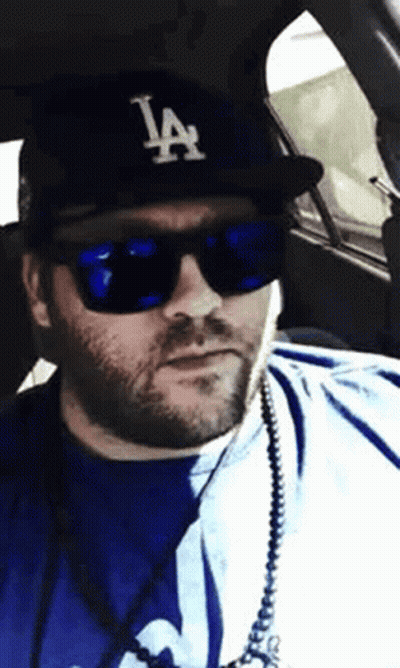 Man In LA Hat And Sunglasses In Car GIF