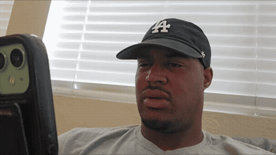 Man In LA Hat Looking At Something GIF