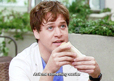 Man in Lab Coat Eating Sandwich Saying Ask Me Something Easier