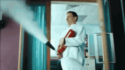 Man In Lab Coat Holding Fire Extinguisher GIF