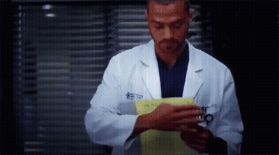 Man In Lab Coat Holding Paper In Front Of Window GIF