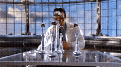 Man In Lab Coat Sitting At Table GIF