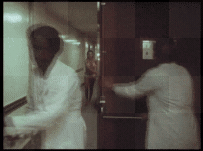 Man In Lab Coat Standing In Hallway GIF