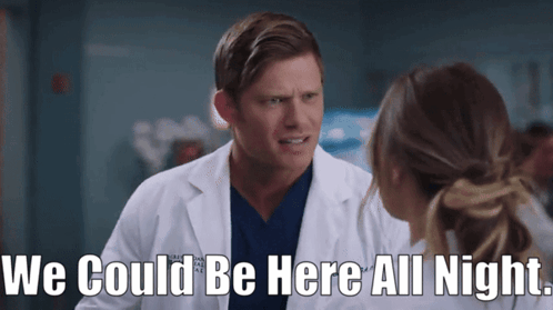 Man In Lab Coat Talking To Woman Says We Could Be Here All Night GIF