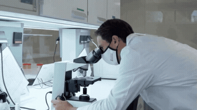 Man In Lab Coat Using Microscope With Mask GIF