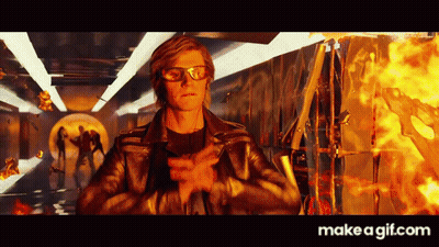 Man in Leather Jacket and Glasses Standing Before Fire