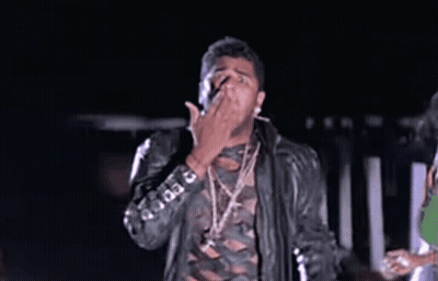Man In Leather Jacket And Necklaces Making Funny Face In Dark GIF