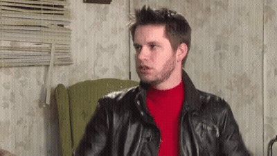 Man In Leather Jacket And Red Sweater Sitting In Chair GIF