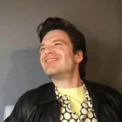 Man In Leather Jacket And Yellow Shirt Smiling GIF