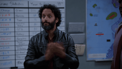 Man In Leather Jacket In Front Of Income Statistics Board GIF