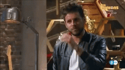 Man In Leather Jacket In Front Of Los Minions Sign GIF