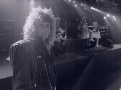 Man in Leather Jacket on Stage With Piano Player