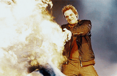 Man In Leather Jacket Standing By Fire GIF