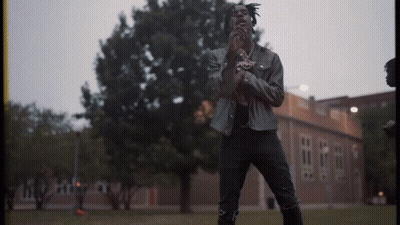 Man In Leather Jacket Standing In Front Of Building GIF