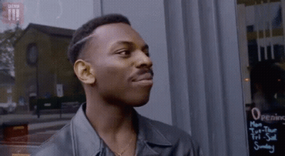 Man In Leather Jacket Standing In Front Of Opening Hours Sign GIF