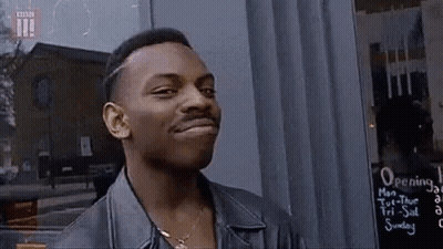 Man In Leather Jacket Standing In Front Of Opening Sign GIF