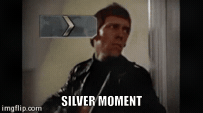 Man In Leather Jacket Standing In Front Of Silver Moment Sign GIF