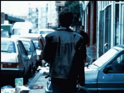 Man In Leather Jacket Walking Down Street GIF