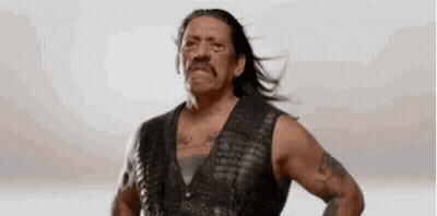 Man In Leather Vest With Hands On Hips Hair Blowing GIF