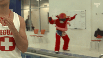 Man in Lifeguard Shirt Stands in Front of Mascot
