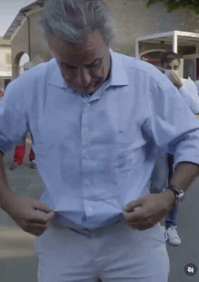 Man In Light Blue Shirt Adjusting White Pants GIF
