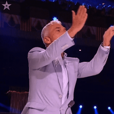 Man In Light Blue Suit On Stage Arms Outstretched GIF