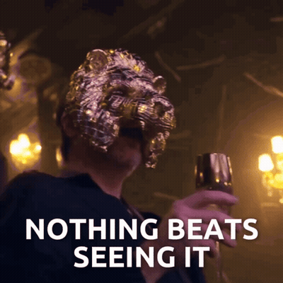 Man In Lion Mask Holding Glass Saying Nothing Beats Seeing It GIF