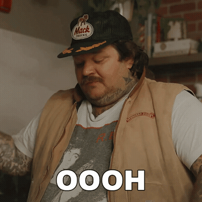 Man In Mack Trucks Hat And Vest Saying Oooh GIF