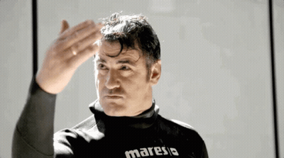 Man In Maresia Wet Suit Hand On Forehead GIF