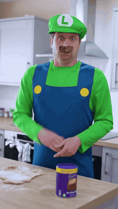 Man In Mario Costume Standing Near Cadbury Chocolate GIF