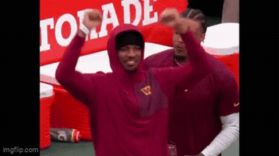 Man In Maroon Hoodie Standing Before Gatorade Sign GIF