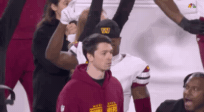Man In Maroon Hoodie With Letter W In Front Of Football Players GIF