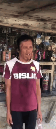 Man In Maroon Shirt Making Funny Face In Front Of Store GIF